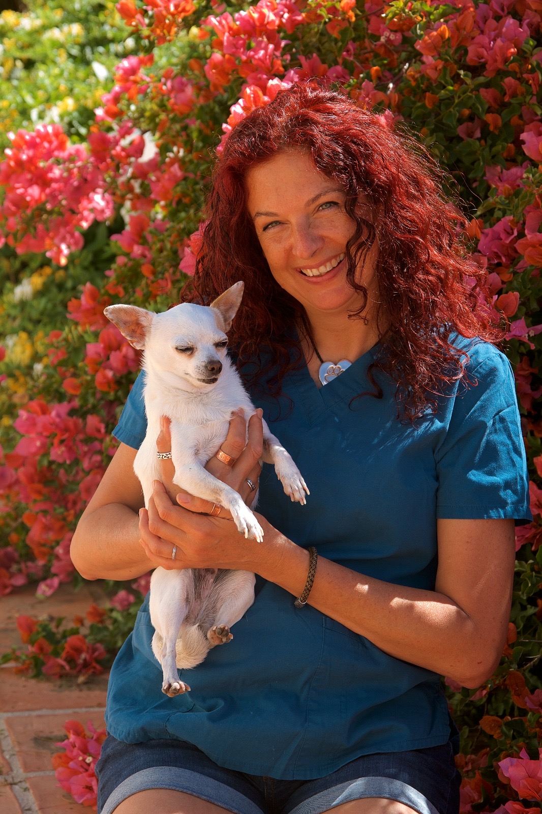 Gunila smiling with a chihuahua in flowers